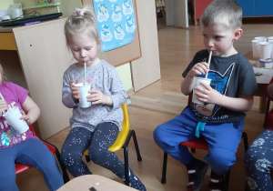 Nikola i Adaś piją koktajl mleczno- owocowy.